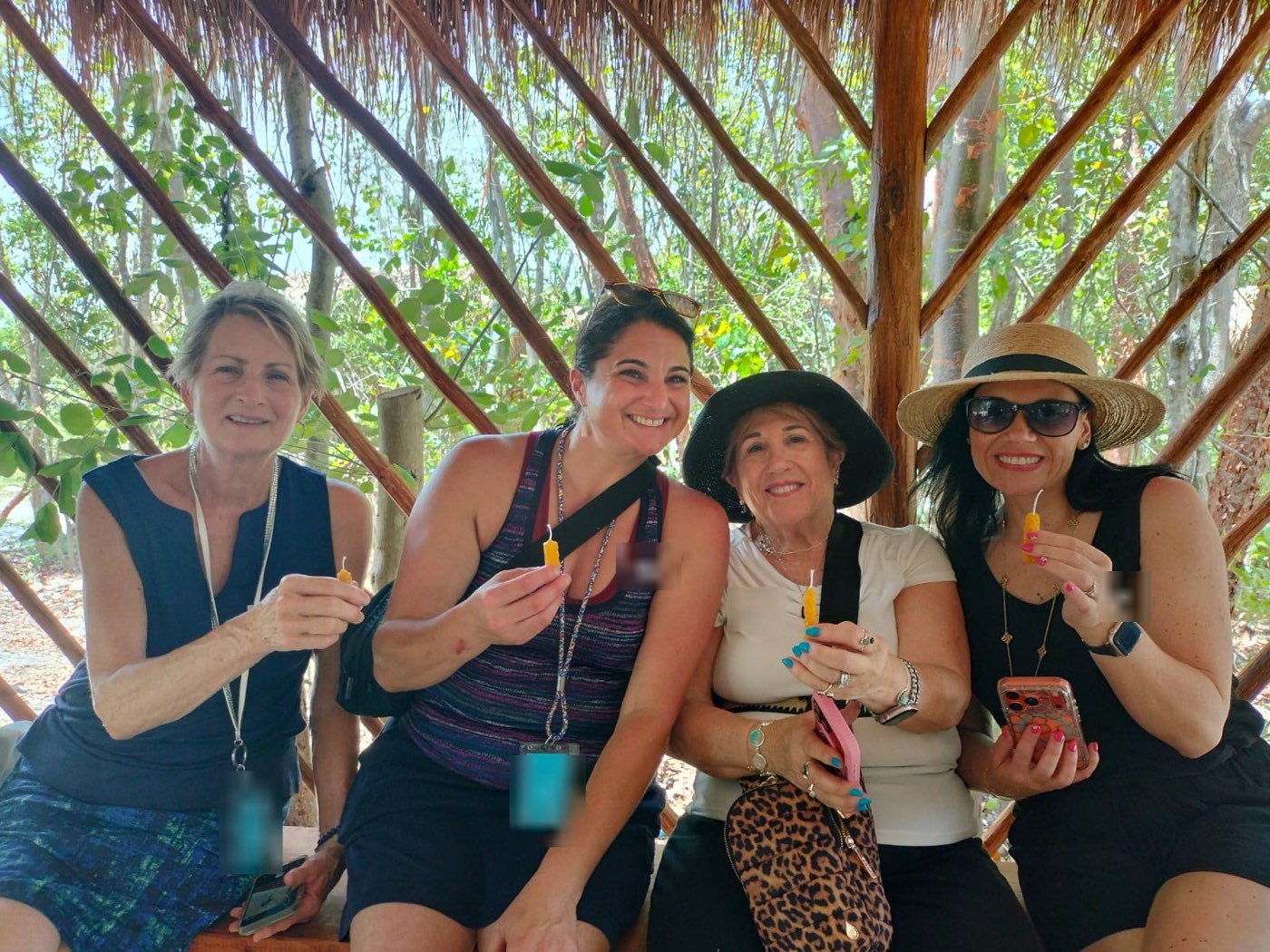 Four guests holding up the beeswax candles they just rolled