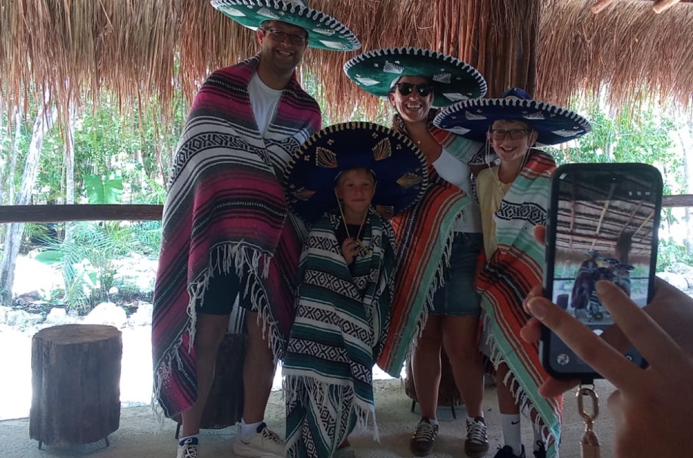 A family wrapped in woven sarapes and sombreros