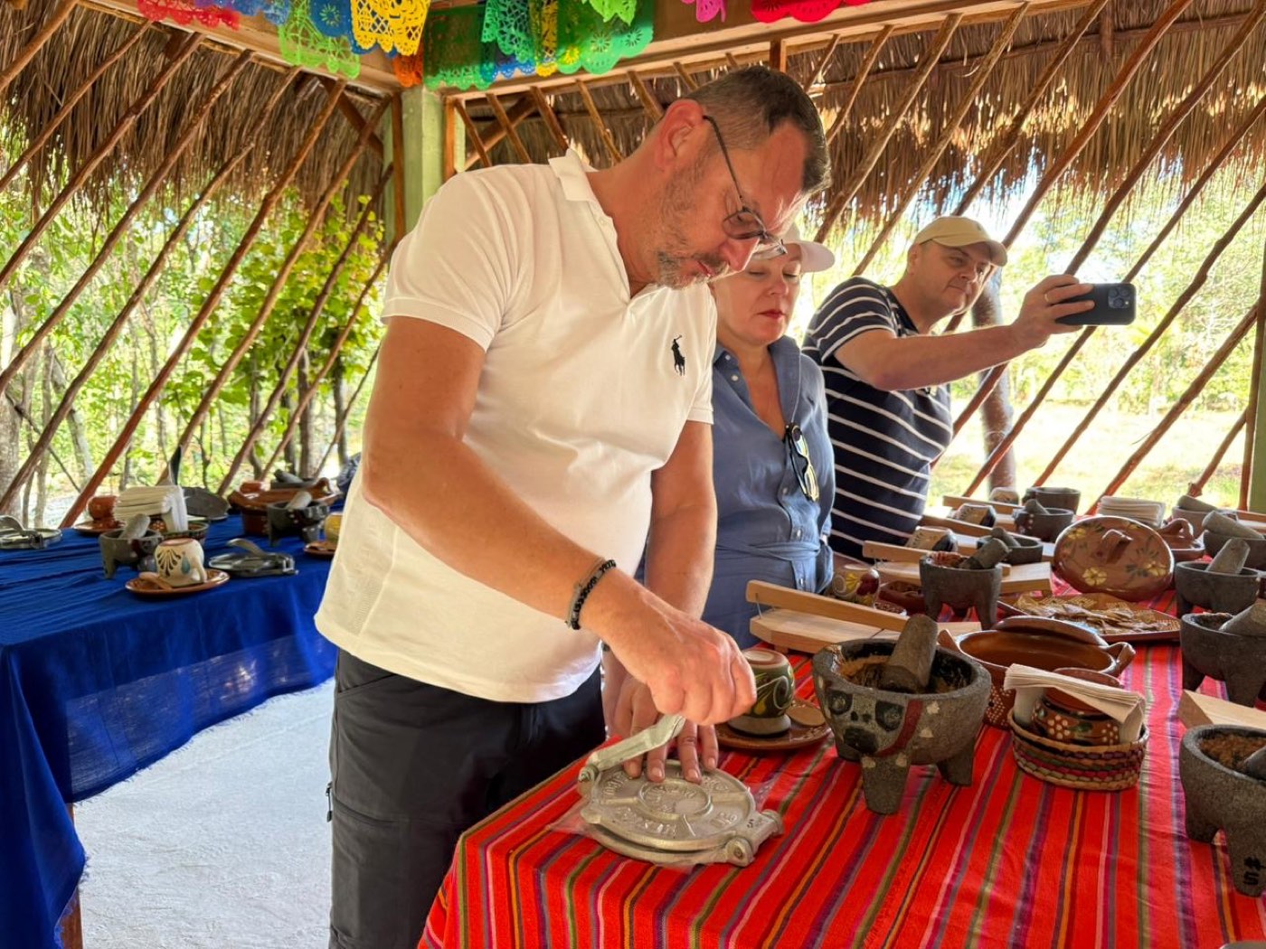 A guest pressing his own corn tortilla