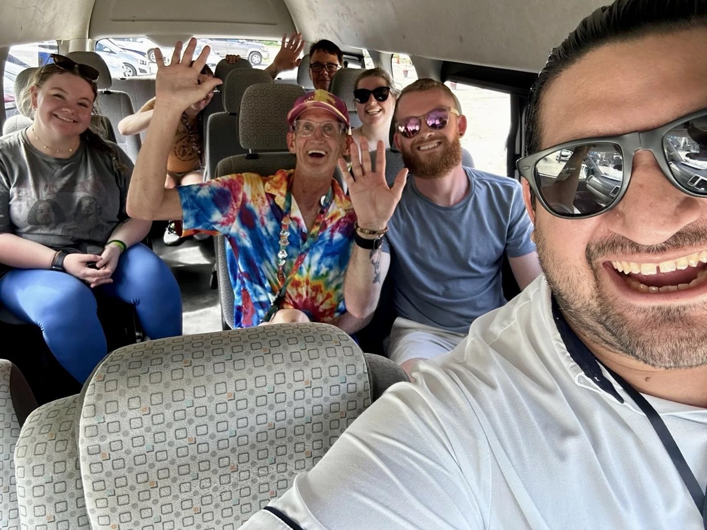 A group waving from inside the van